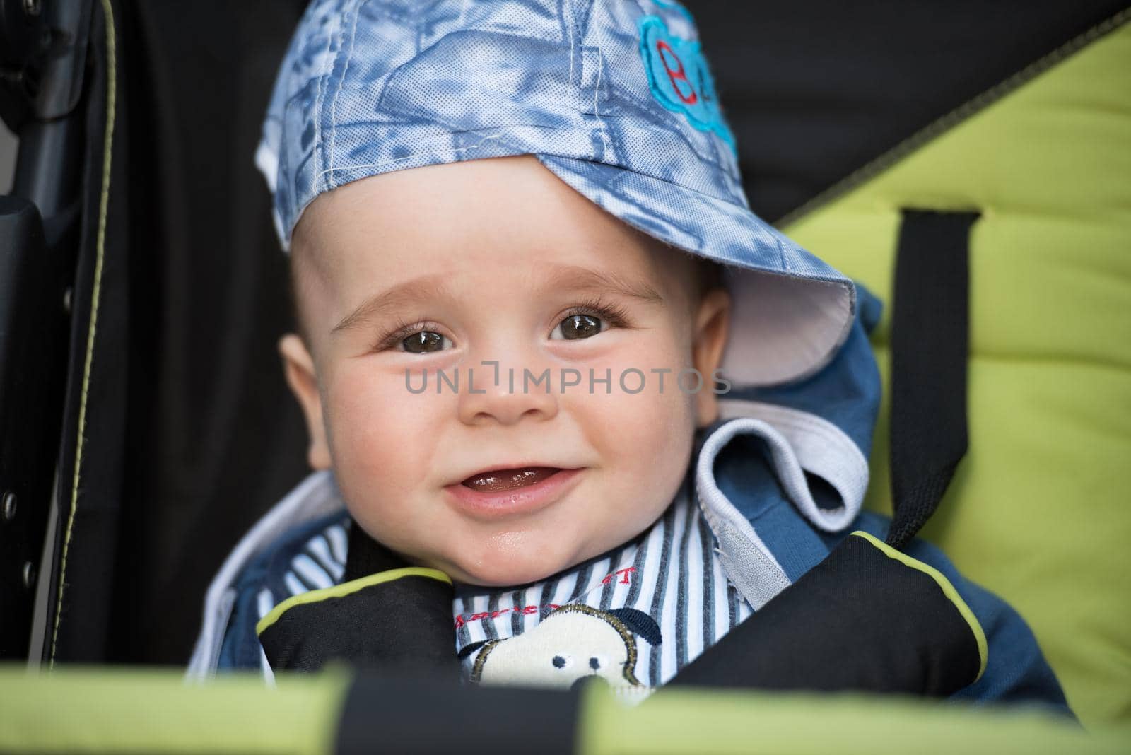 little and very beautiful baby boy sitting in the pram and waiting for mom