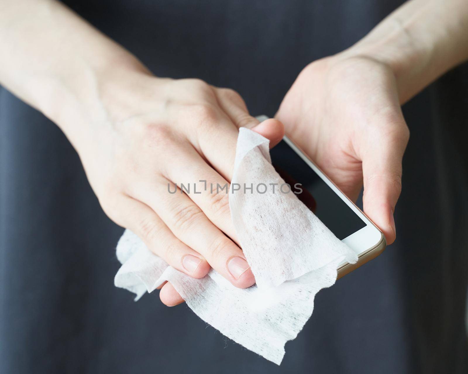 Woman wash cell phone with wet wipes, to prevent illness Novel coronavirus 2019-nCoV after public place. Antiseptic, Hygiene and Healthcare concept