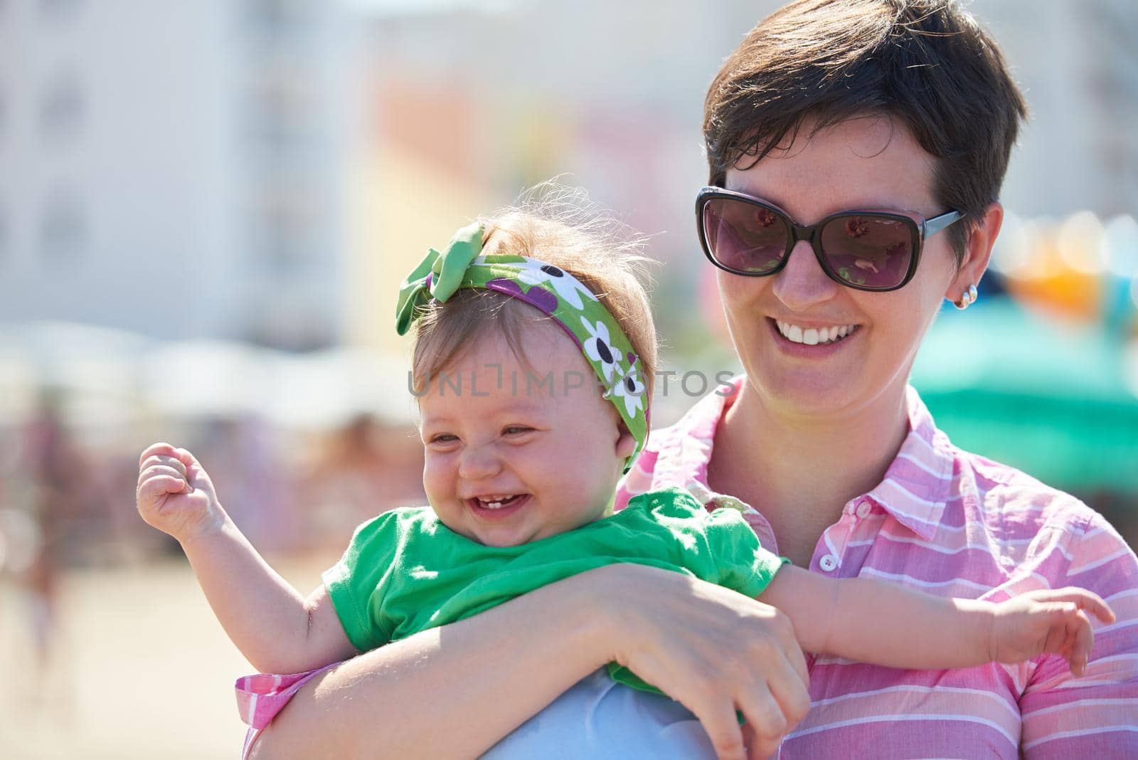 happy mom and baby on beach  have fun while learning to walk and  make first steps