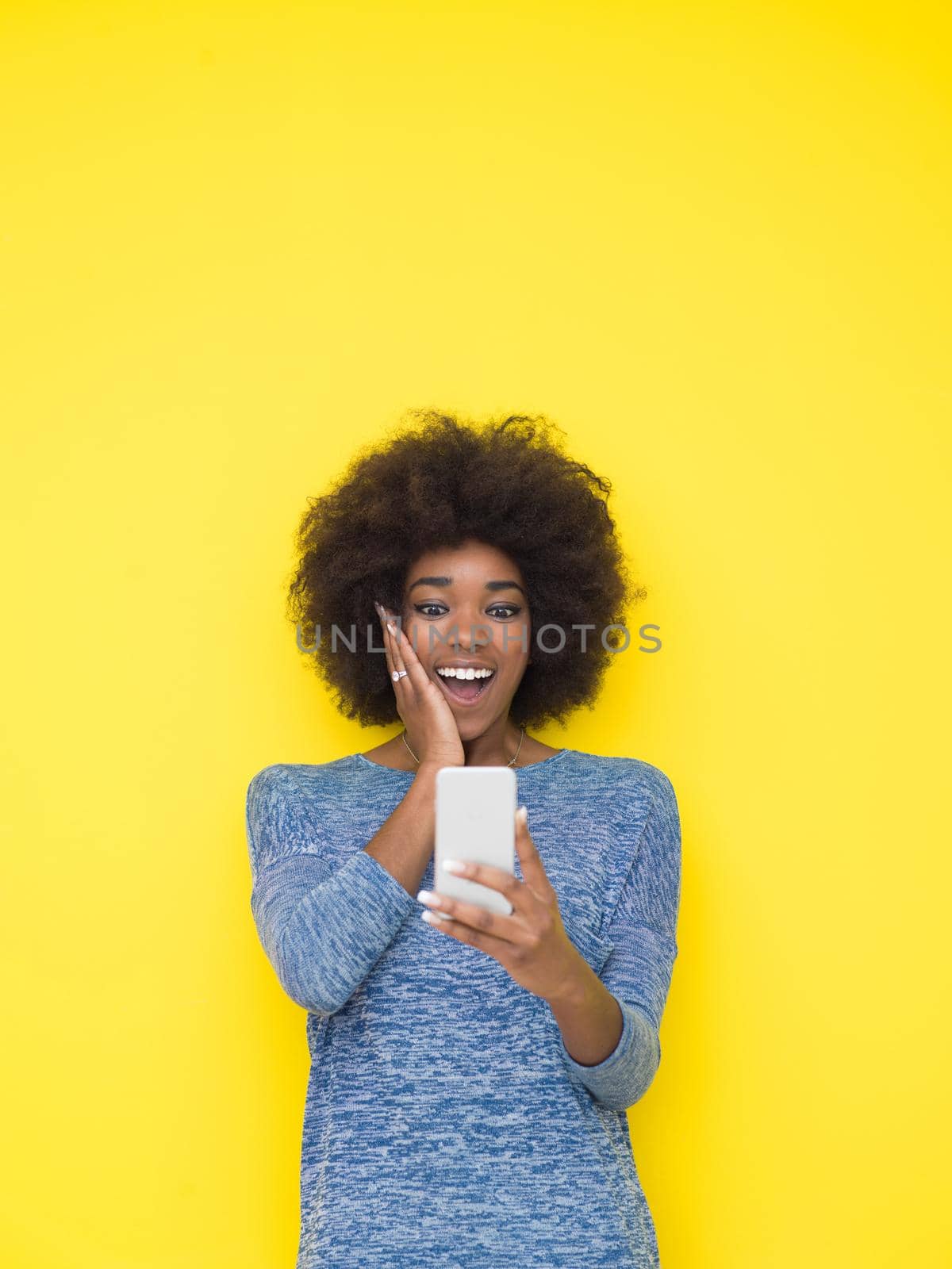 Young Happy African American Woman Using mobile phone  Isolated on a yellow background