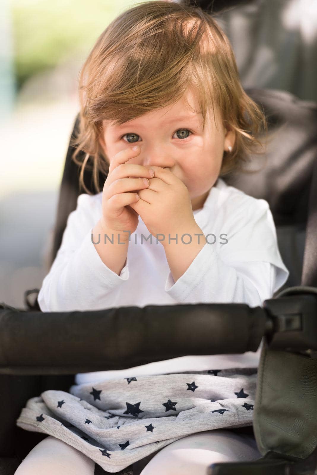 little and very beautiful baby girl sitting in the pram and waiting for mom