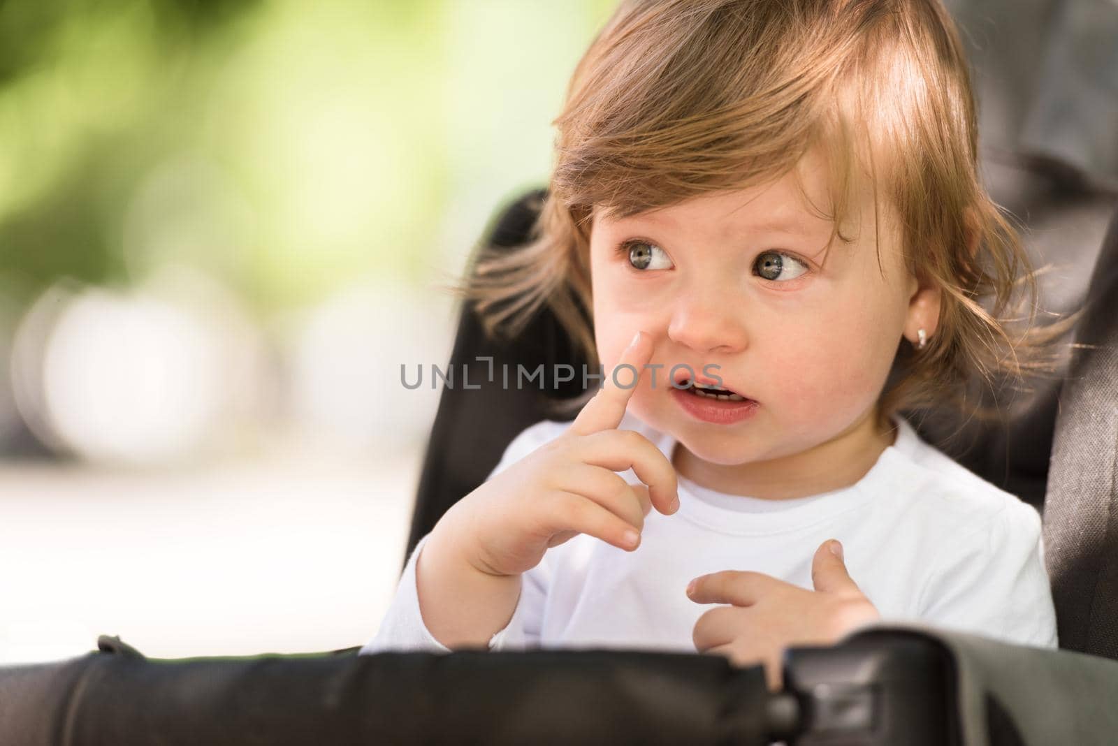 little and very beautiful baby girl sitting in the pram and waiting for mom