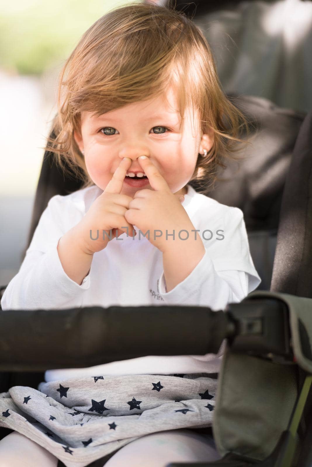 little and very beautiful baby girl sitting in the pram and waiting for mom