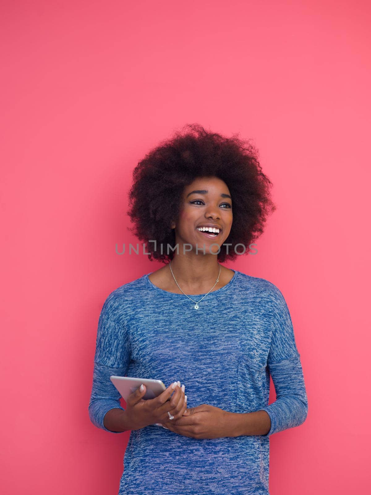 Young Happy African American Woman Using Digital Tablet  Isolated on a pink background