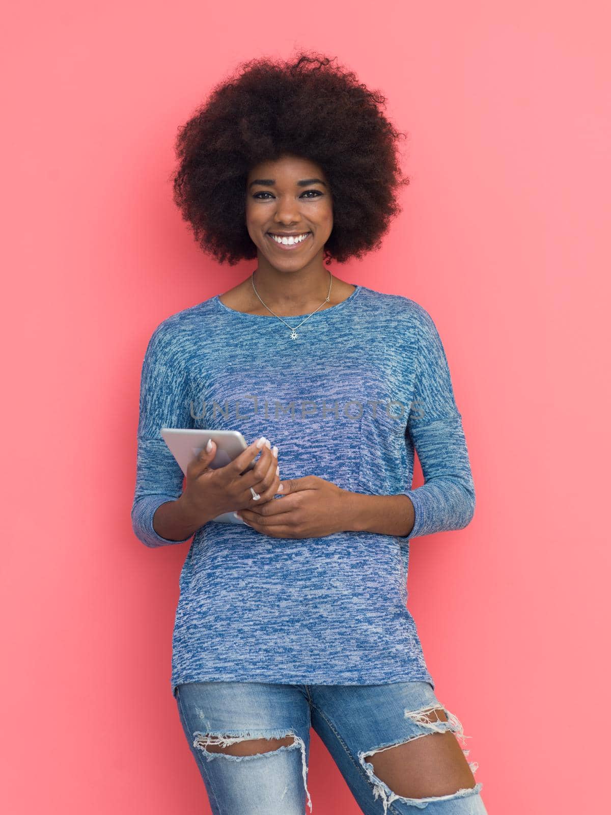 Young Happy African American Woman Using Digital Tablet  Isolated on a pink background