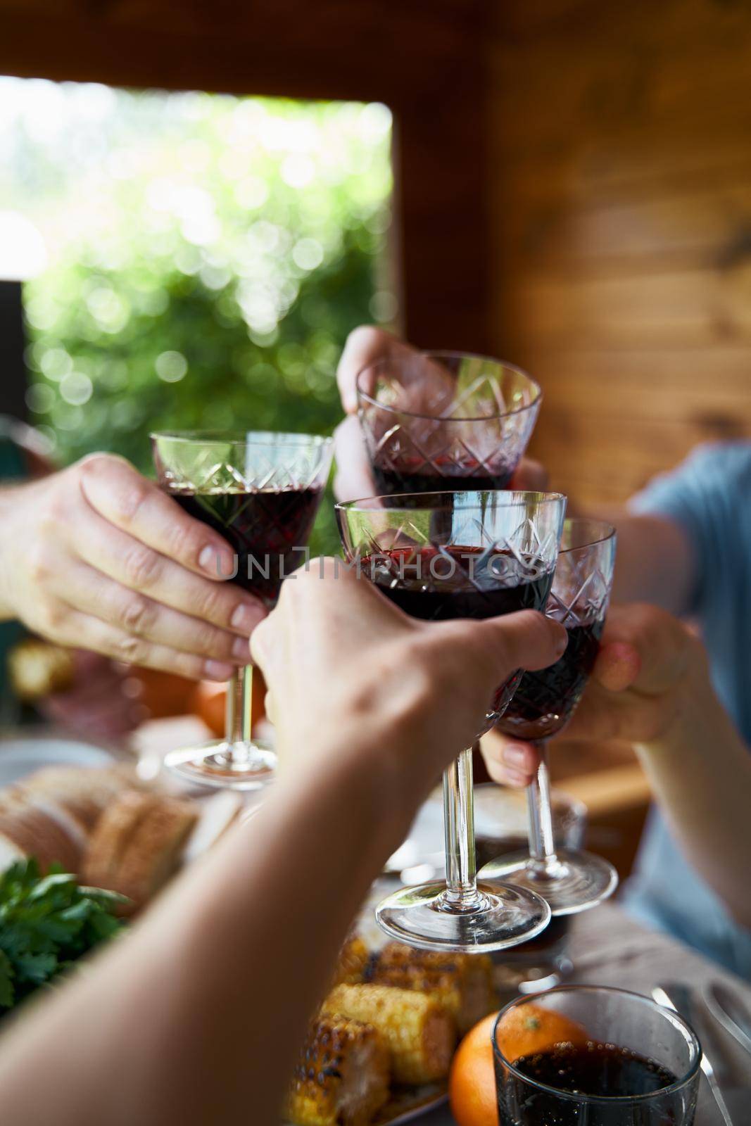 Cropped hands of anonymous people holding glasses full of alcohol beverage celebration event concept of holiday weekend leisure vertical