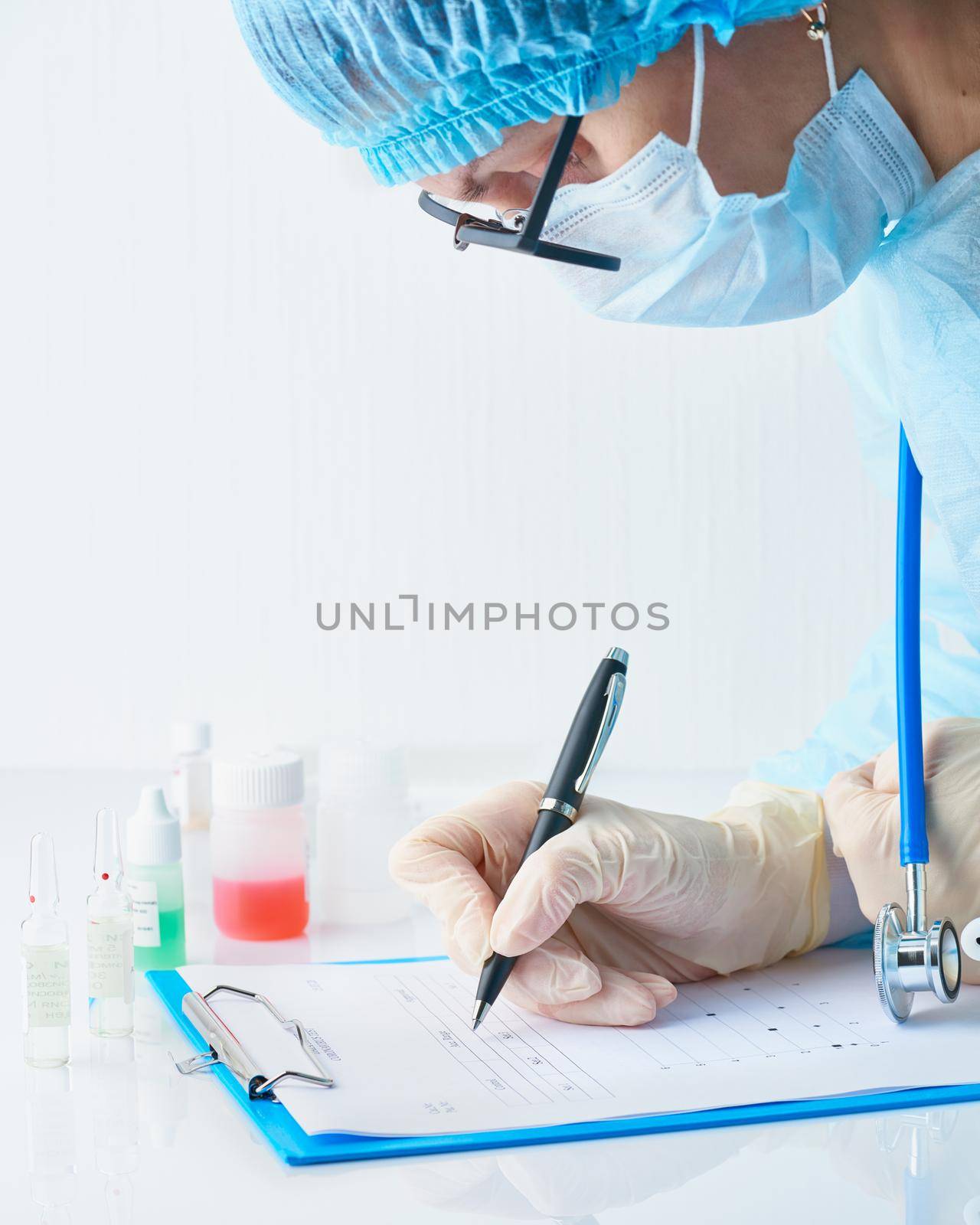 Pandemic COVID-19, Coronavirus. Doctor in hospital is on duty, avail for work, filling out forms. Woman in uniform and face mask conducts tests in laboratory, writes down results.