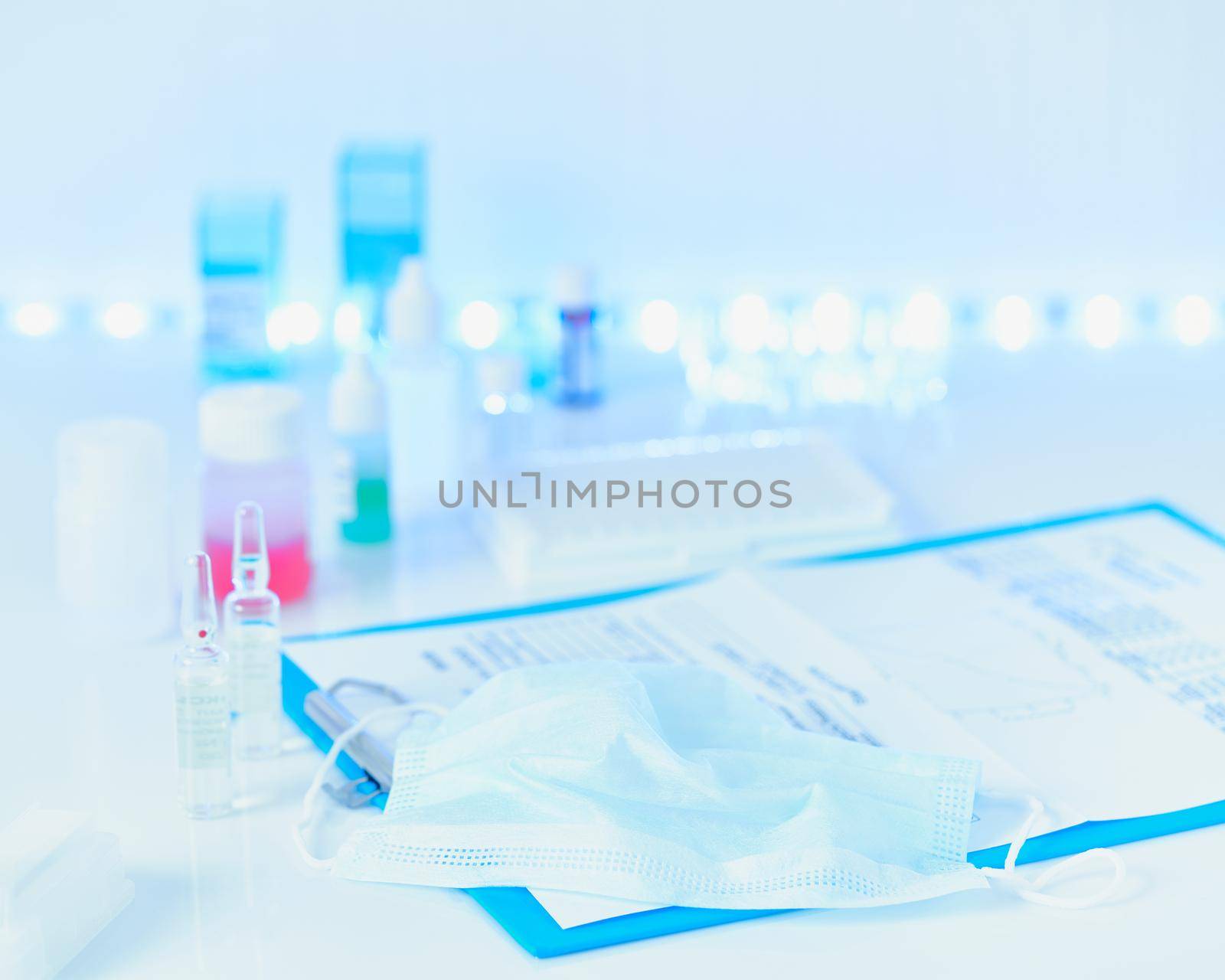 Pandemic COVID-19, Coronavirus. Nobody. Medical blue blurred backdrop with supplies, tests, bottles, microscope, clipboard with notes on table. Concept of laboratory. Selective focus