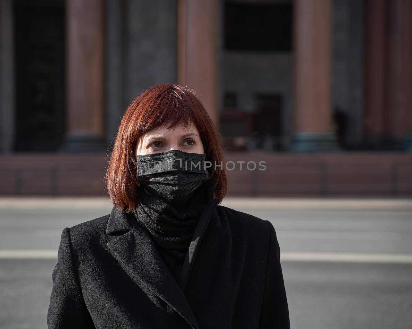 A sad woman with mask on her face stands near closed Museum. Ban on walking and visiting public places due to coronavirus pandemic