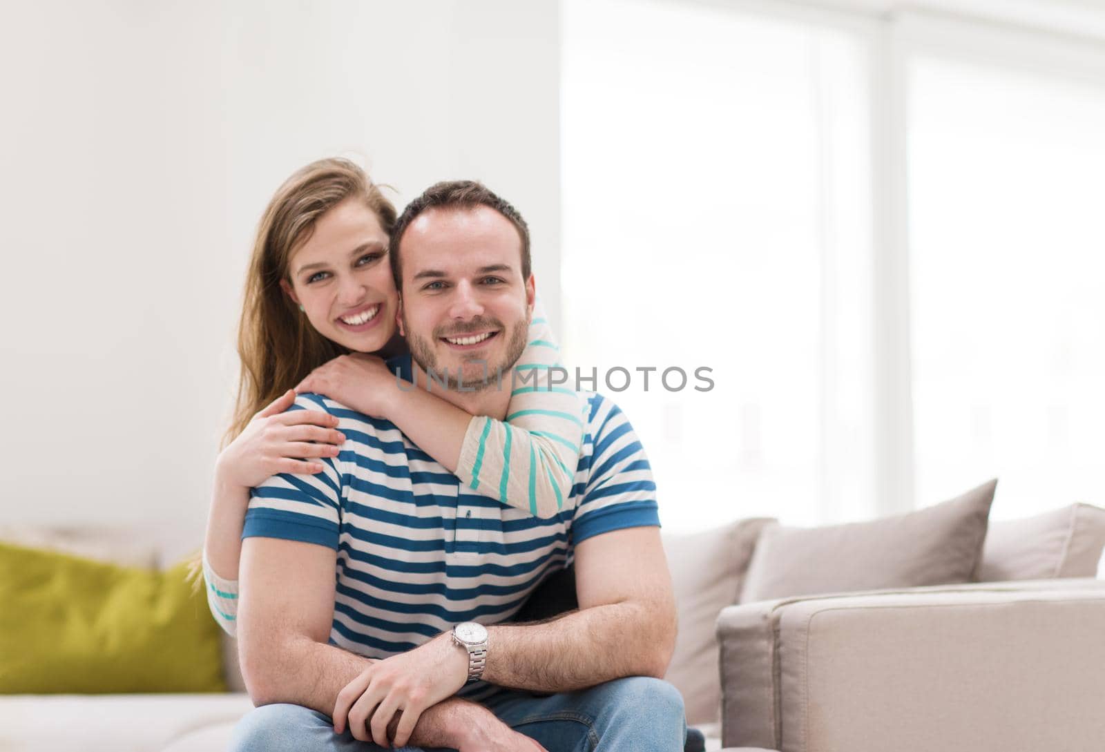 young handsome couple enjoys hugging on the sofa in their luxury home villa