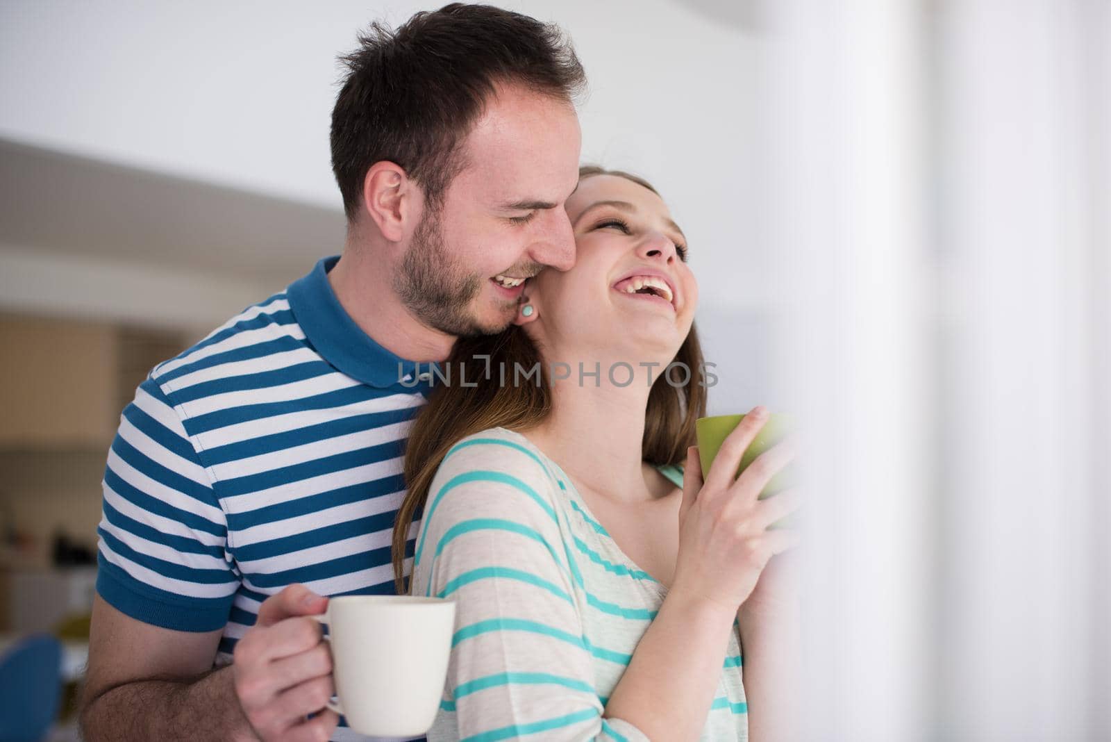 young beautiful handsome couple enjoying morning coffee at home