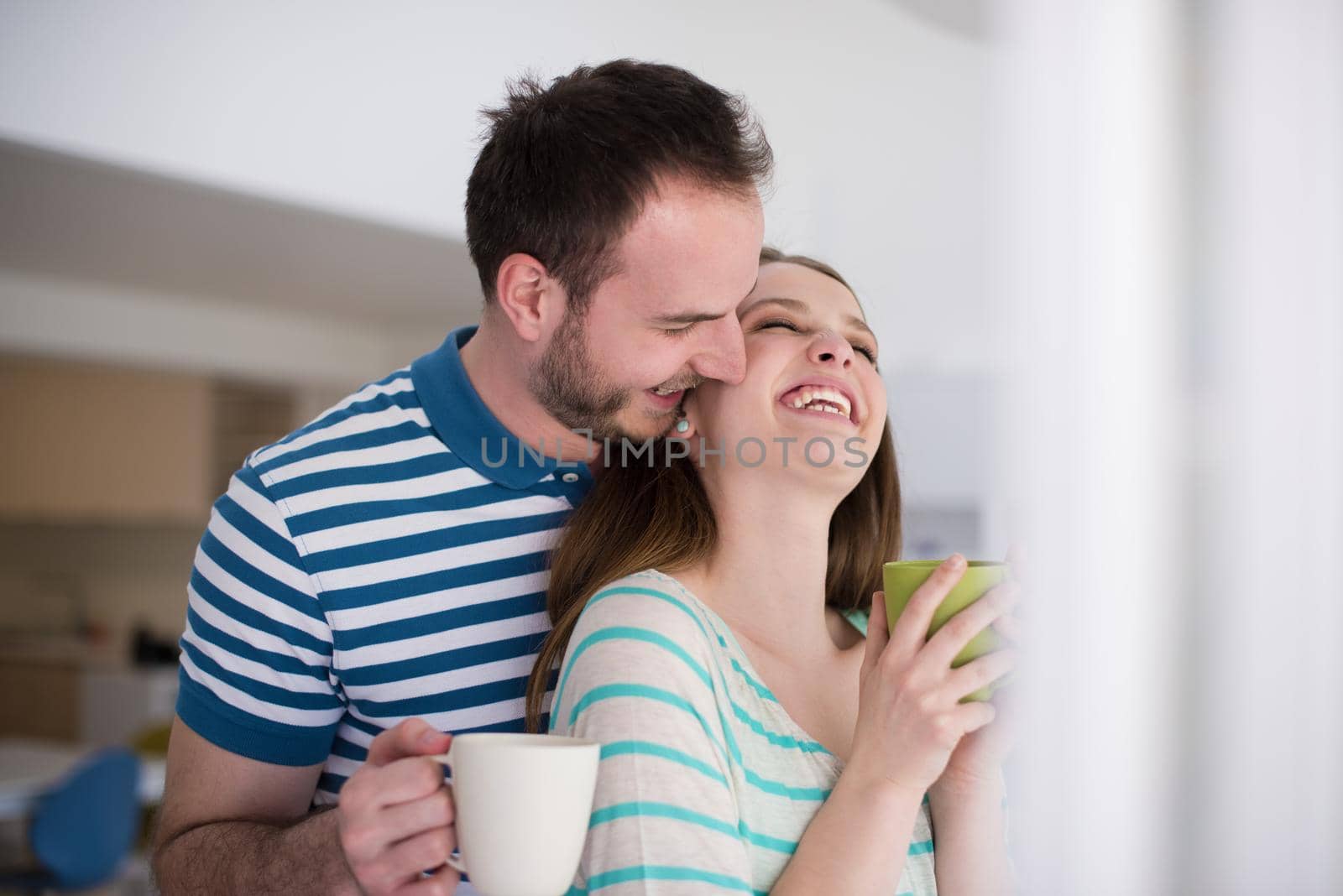 young beautiful handsome couple enjoying morning coffee at home