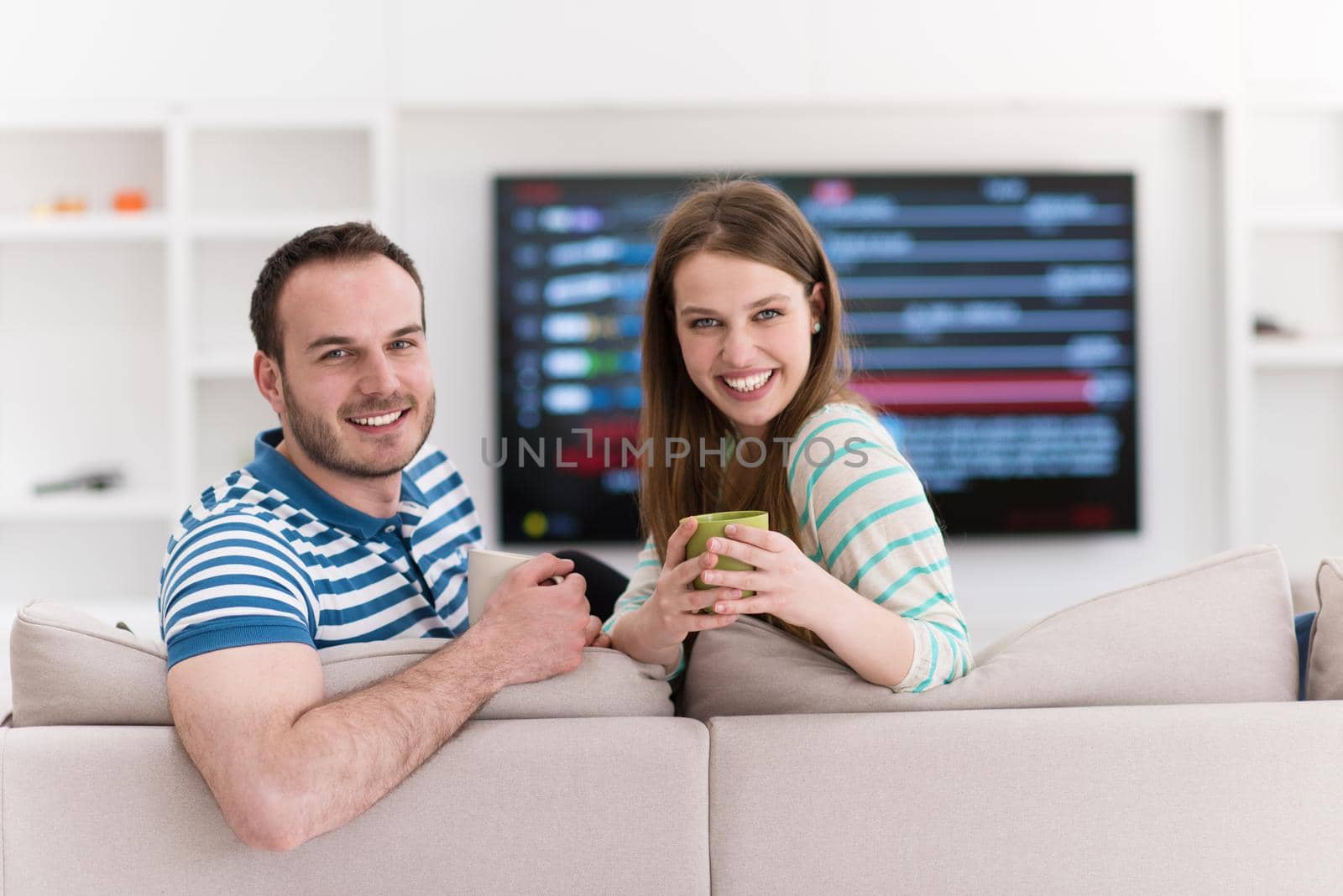 young beautiful handsome couple enjoying morning coffee at home