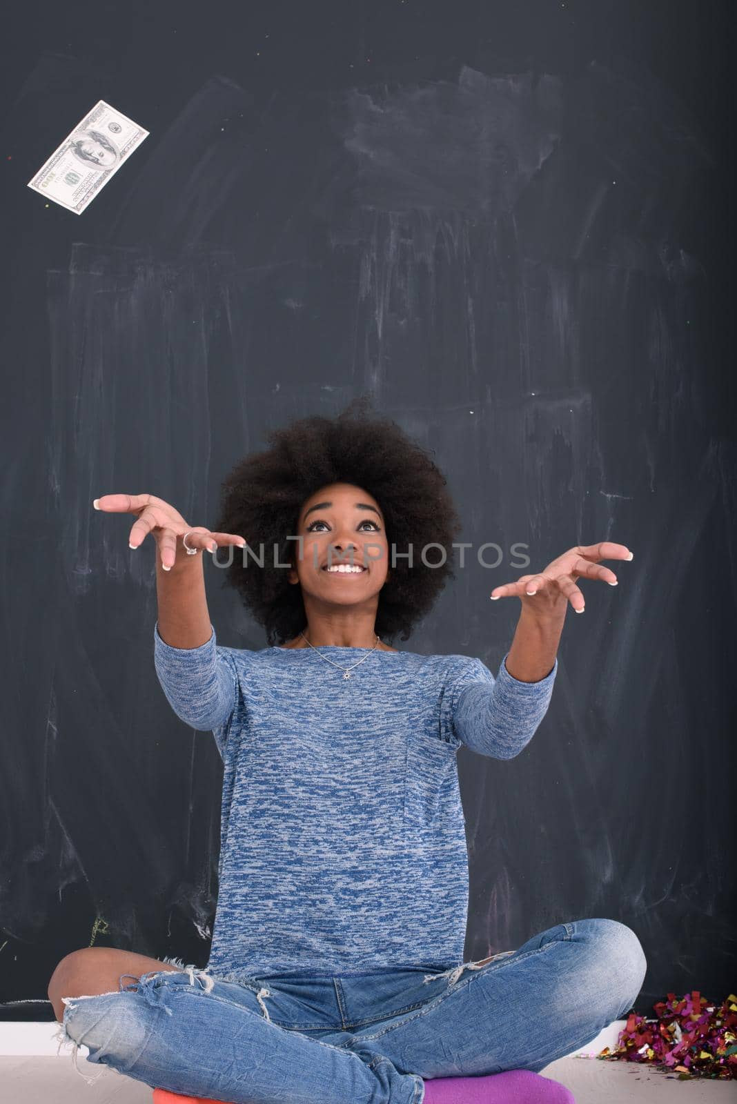 beautiful smiling afro american woman throwing money isolated on a gray background