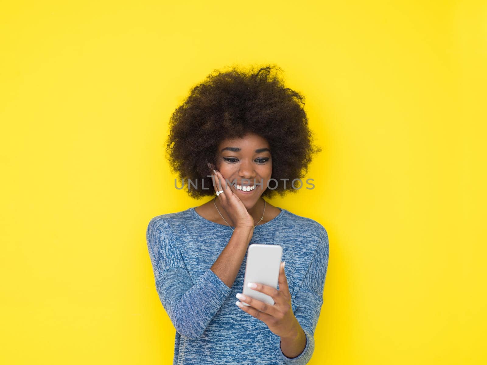 Young Happy African American Woman Using mobile phone  Isolated on a yellow background