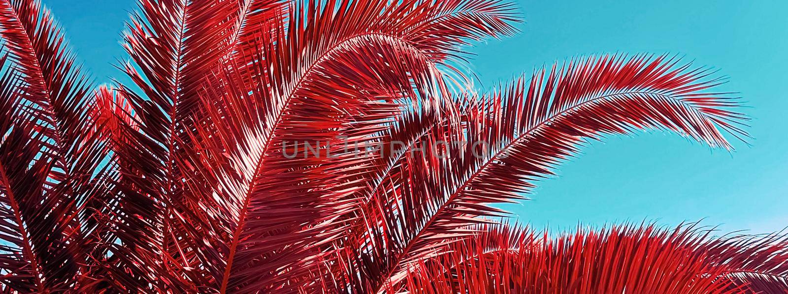 Pop art and tropical nature concept. Red palm tree leaves and blue sky as vintage summer background.