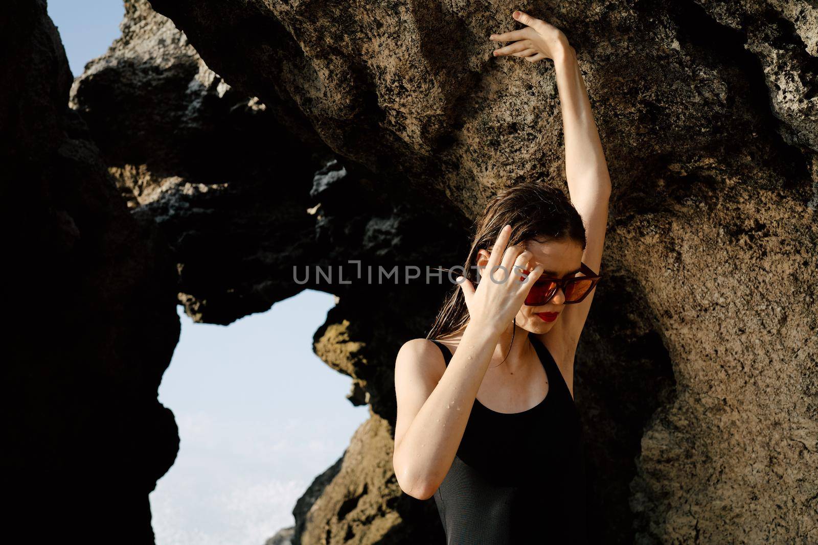 woman in black swimsuit posing near rocks ocean exotic. High quality photo