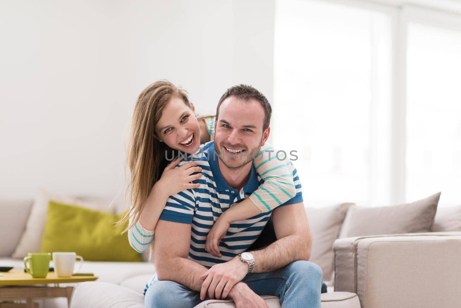 young handsome couple enjoys hugging on the sofa in their luxury home villa