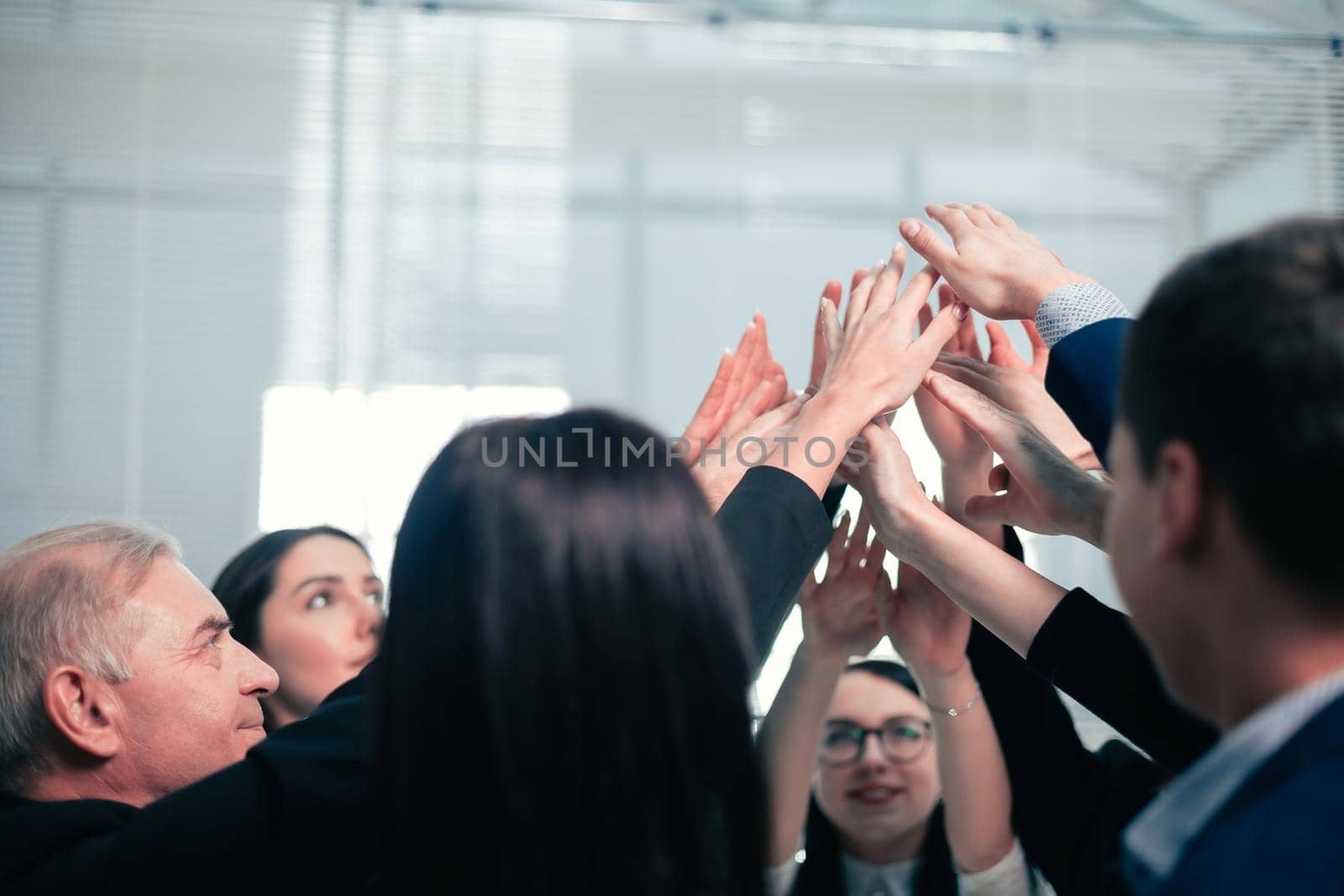 close up. a group of employees joining their palms by SmartPhotoLab