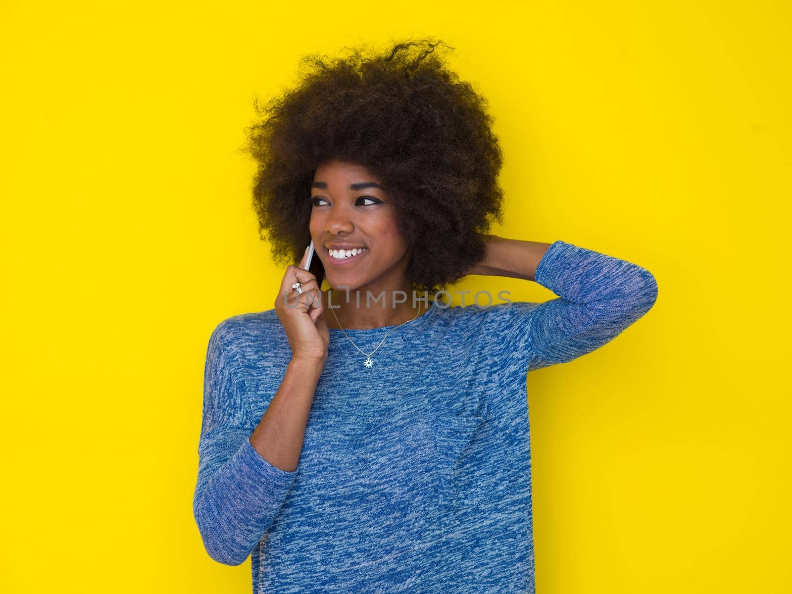 Young Happy African American Woman Using mobile phone  Isolated on a yellow background