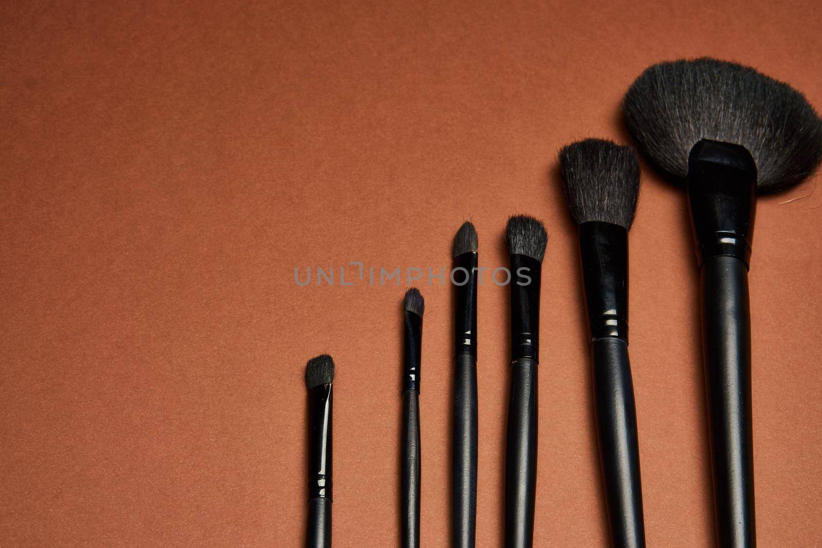 makeup brushes mascara accessories glamor brown background by Vichizh