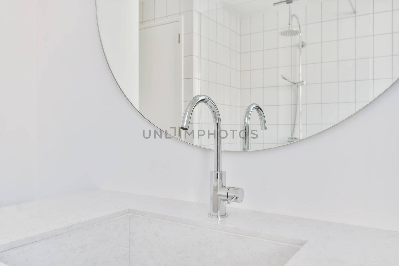 Delightful sink with faucet in front of round mirror