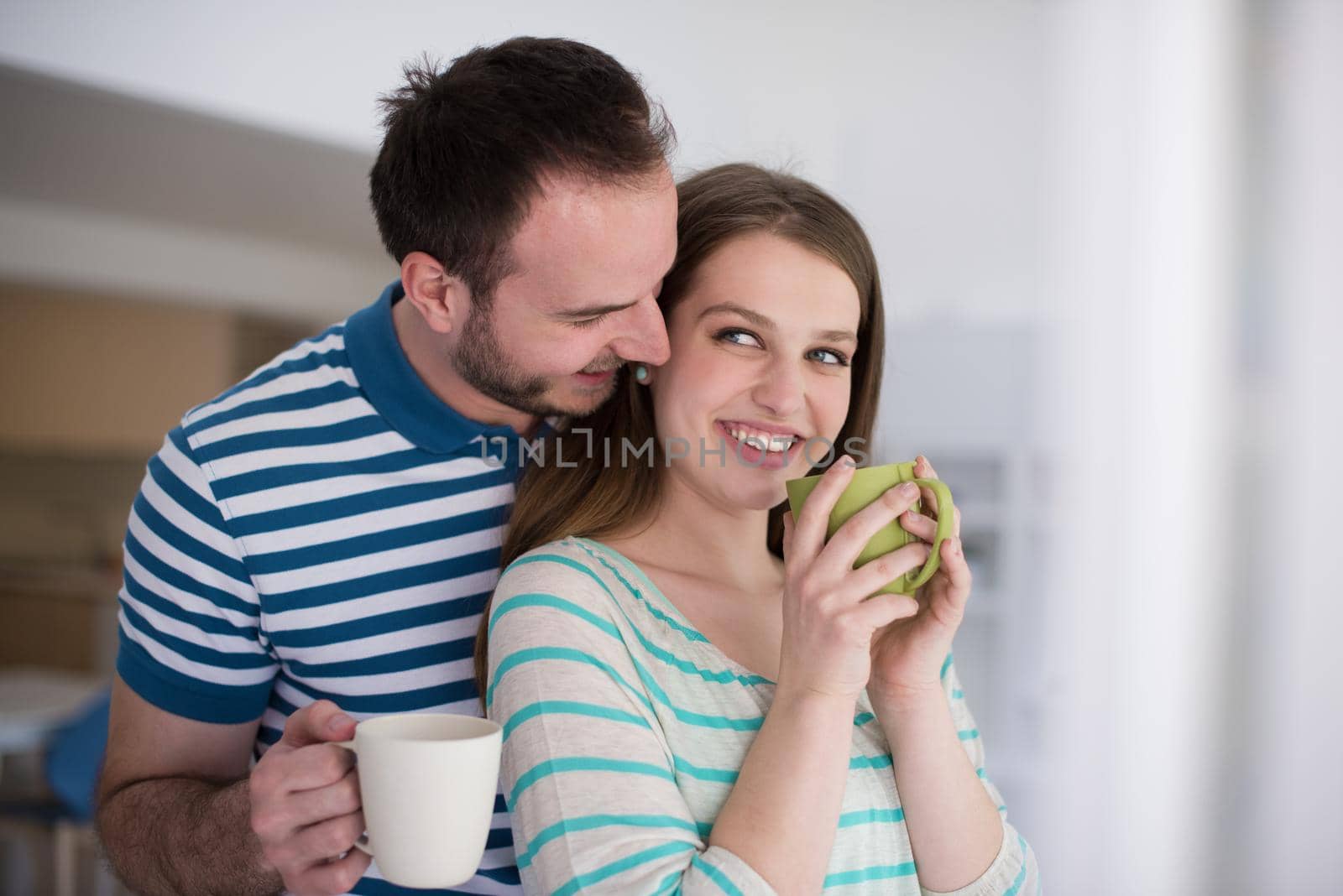 young beautiful handsome couple enjoying morning coffee at home