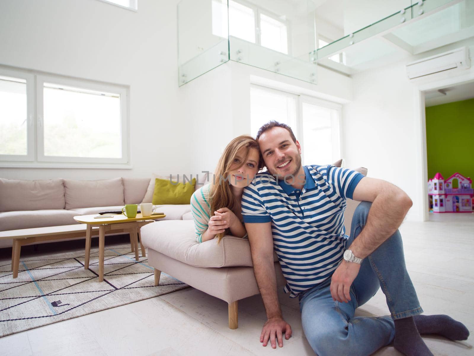 young handsome couple enjoys hugging on the sofa in their luxury home villa