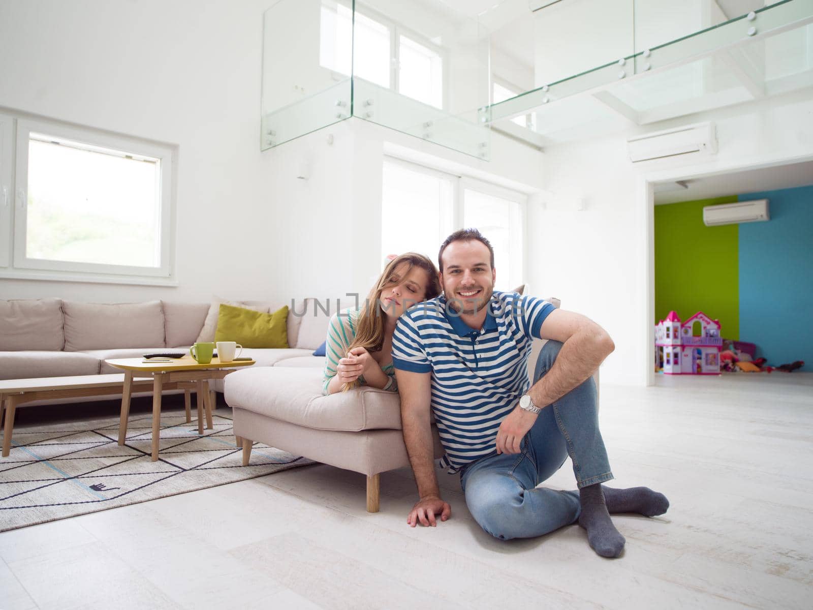 young handsome couple enjoys hugging on the sofa in their luxury home villa