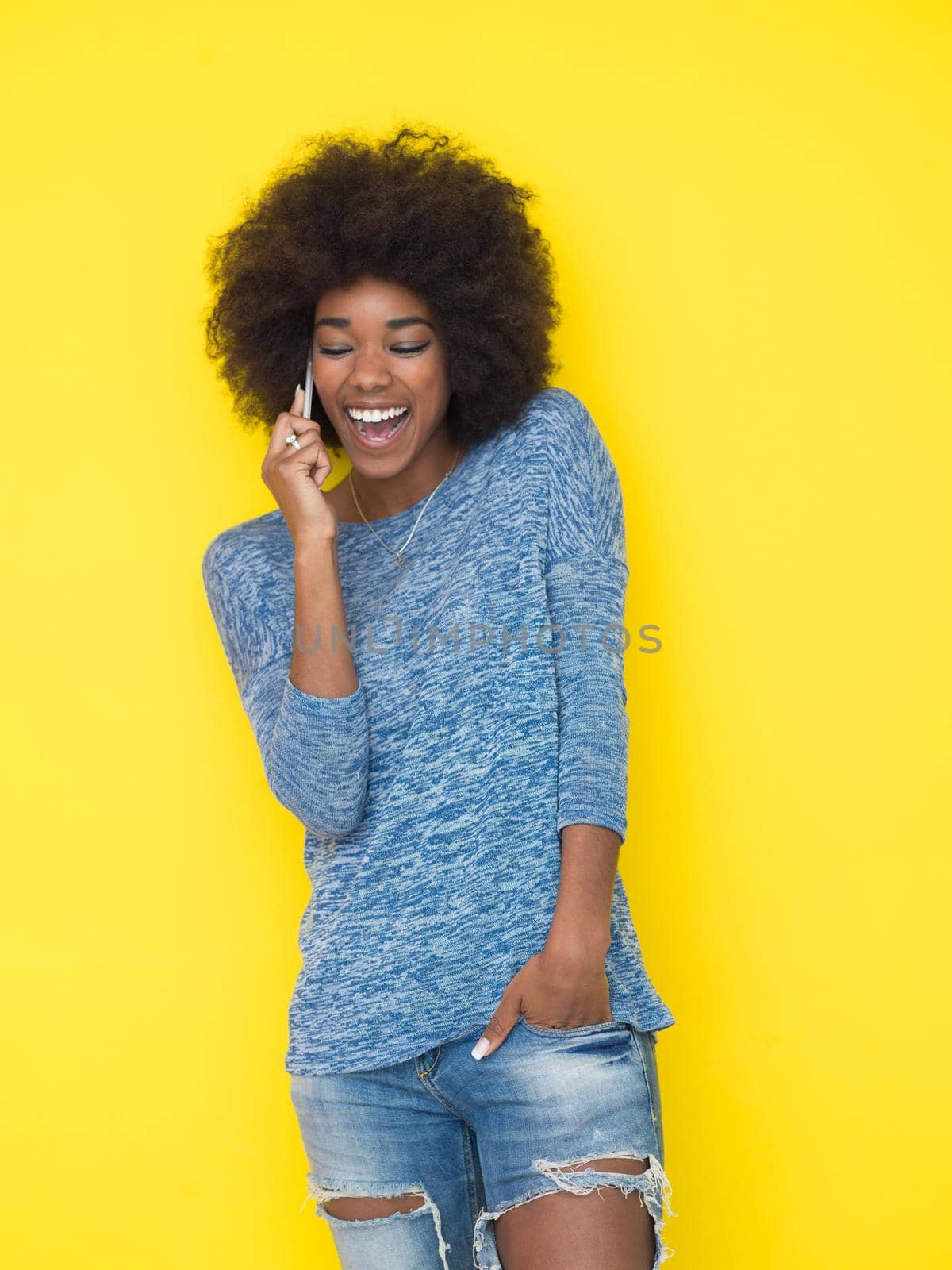 Young Happy African American Woman Using mobile phone  Isolated on a yellow background