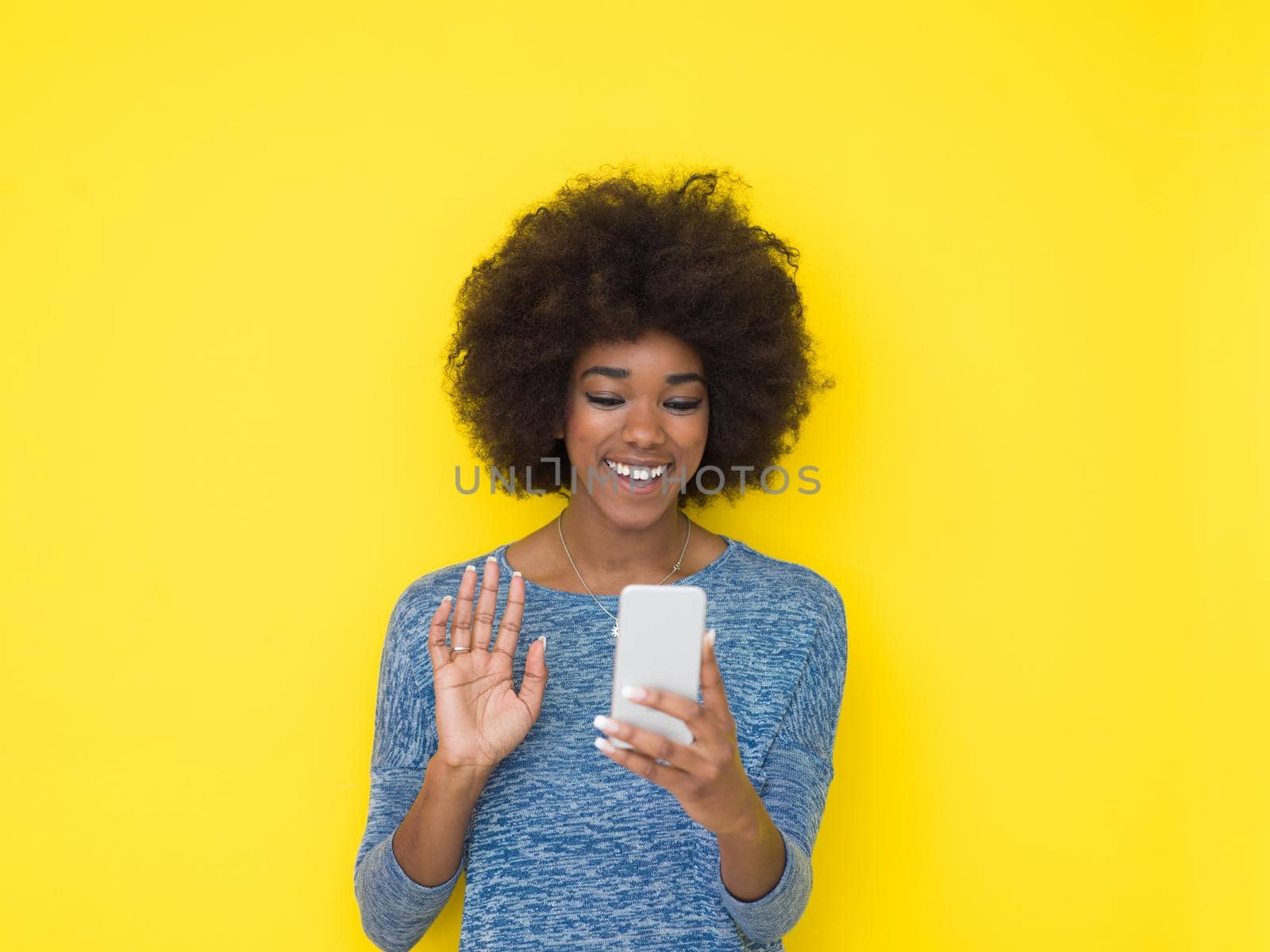Young Happy African American Woman Using mobile phone  Isolated on a yellow background