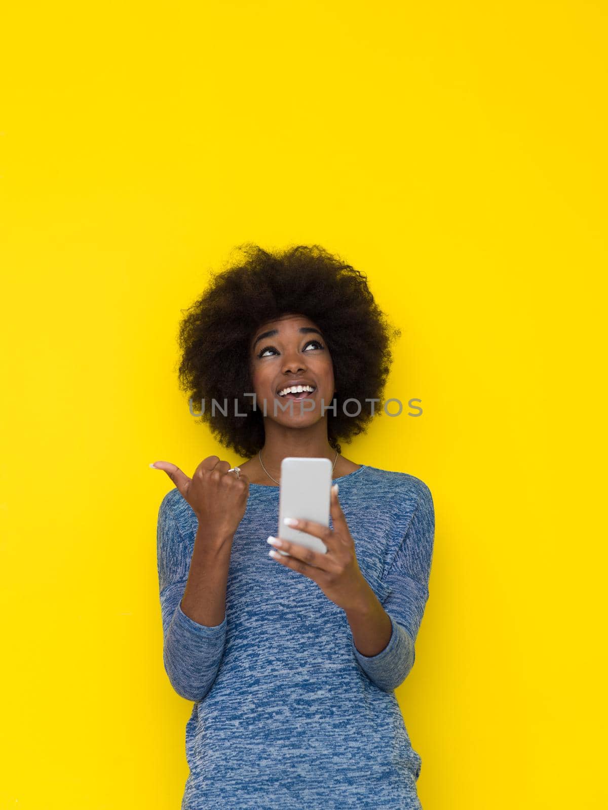 Young Happy African American Woman Using mobile phone  Isolated on a yellow background