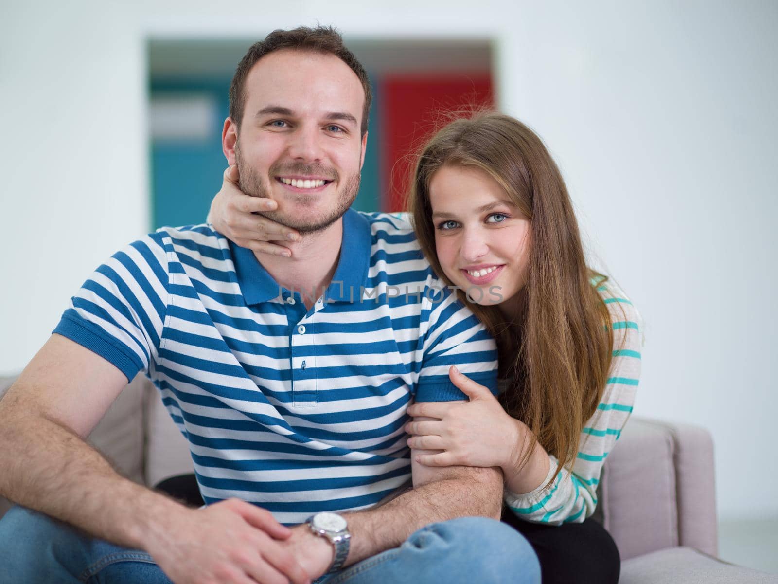 young handsome couple enjoys hugging on the sofa in their luxury home villa