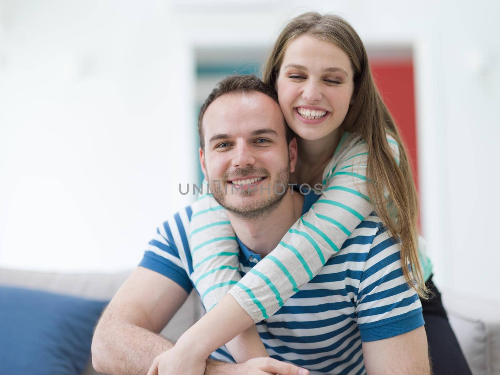 young handsome couple enjoys hugging on the sofa in their luxury home villa