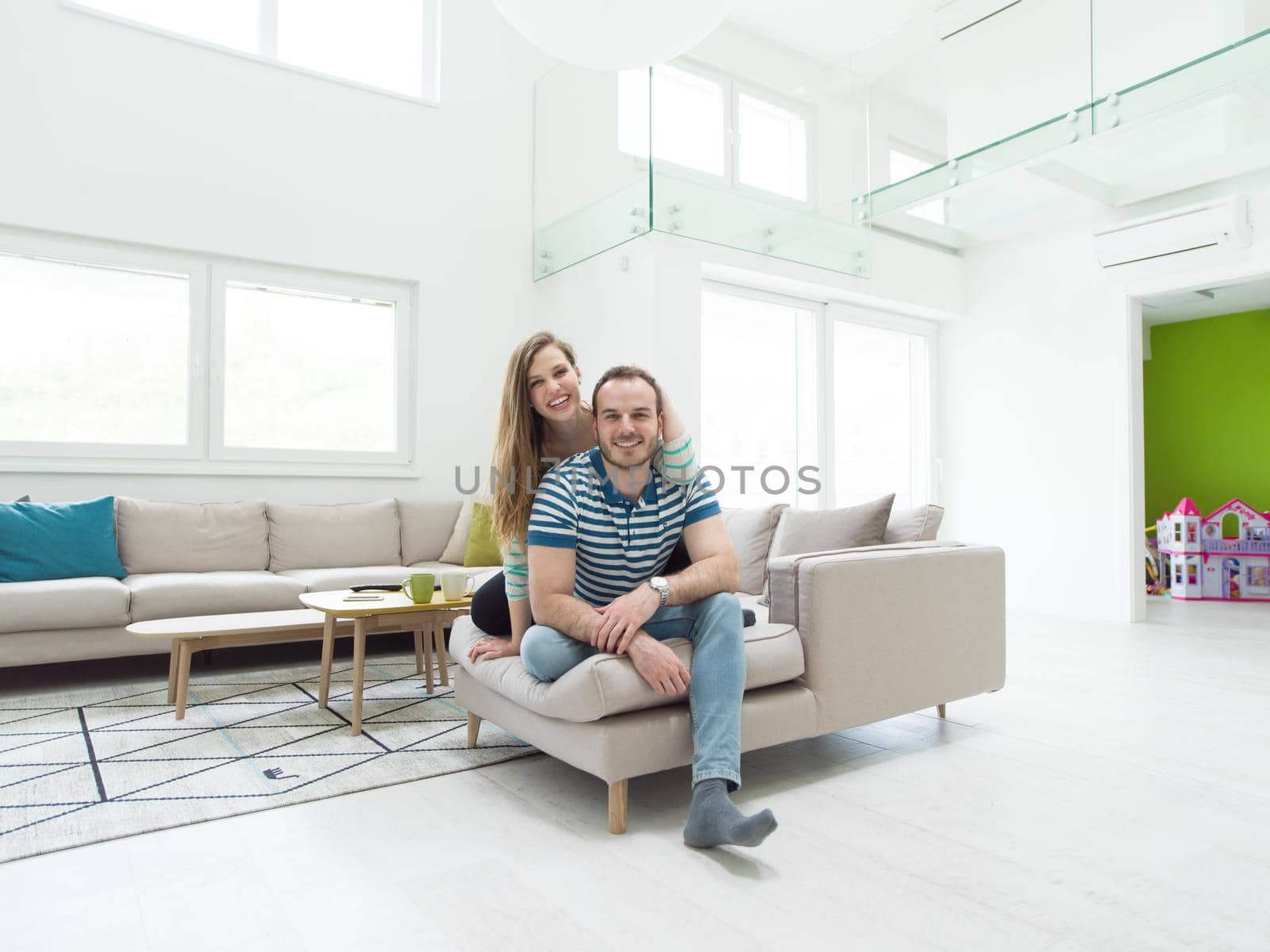 young handsome couple enjoys hugging on the sofa in their luxury home villa