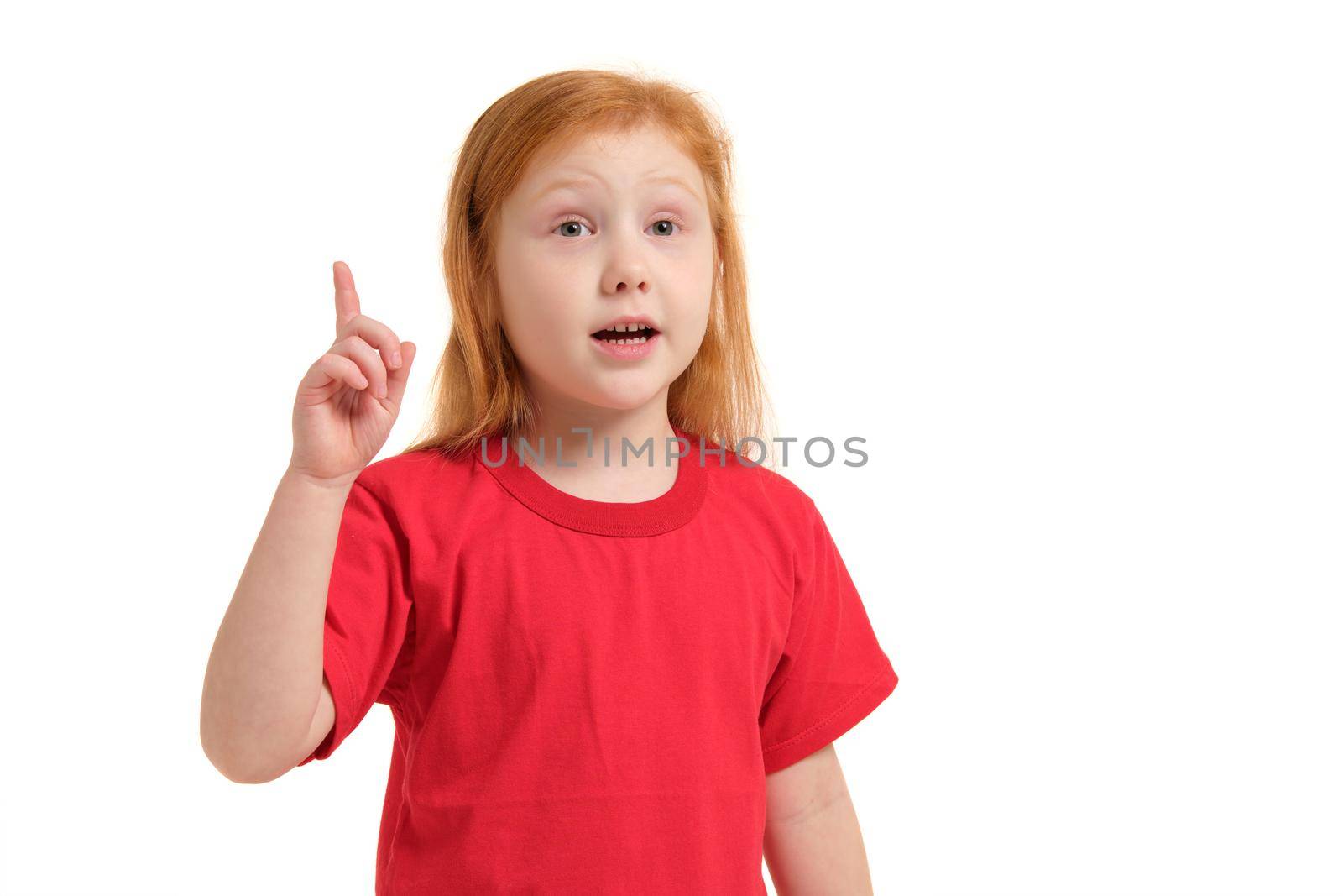 Portrait of cute redhead emotional little girl in red t-shirt isolated on a white. Beautiful studio portrait of female little caucasian person