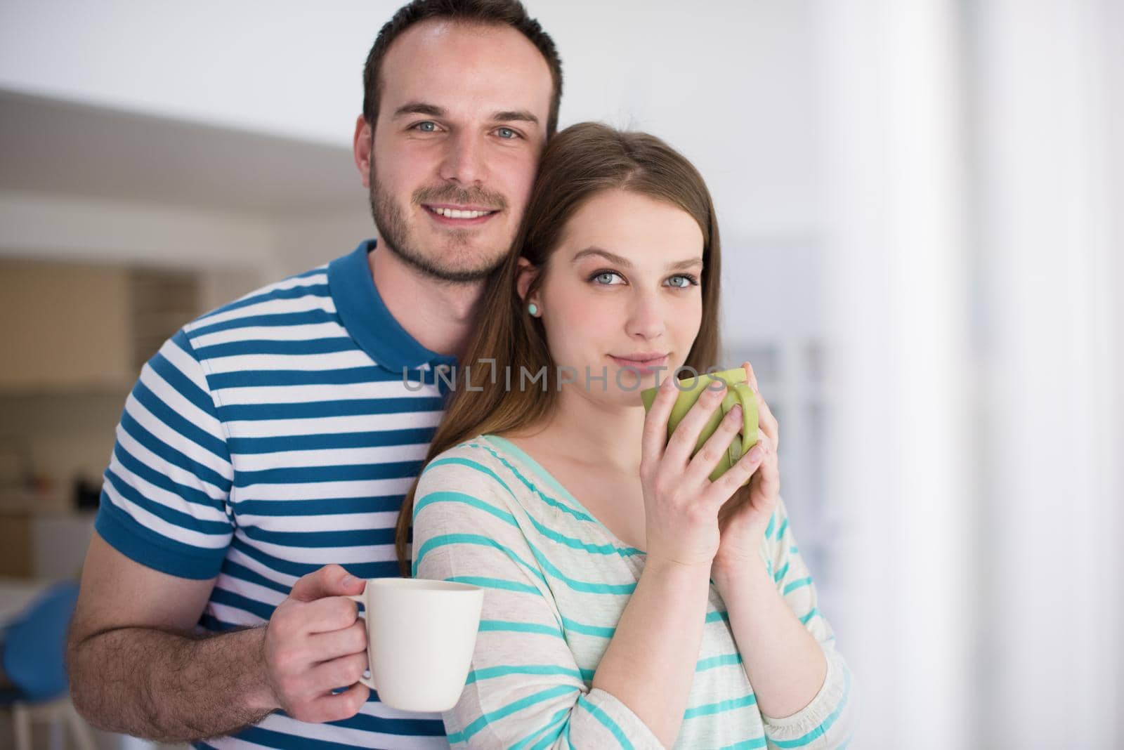 young beautiful handsome couple enjoying morning coffee at home