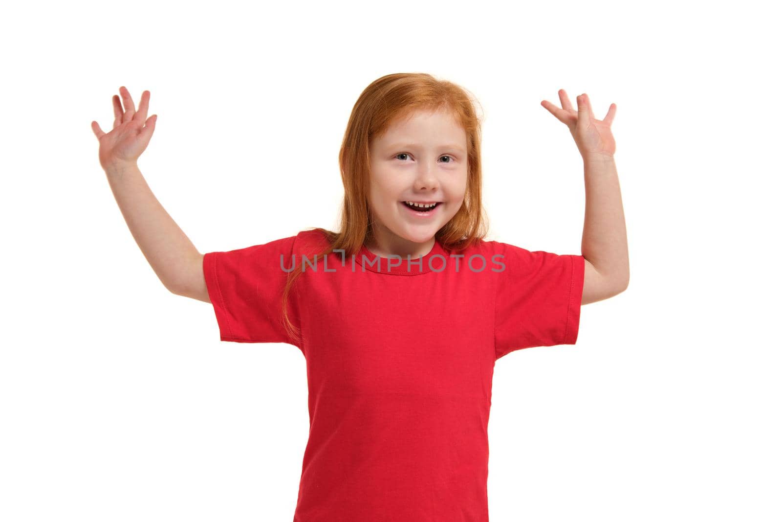 Portrait of cute redhead emotional little girl in red t-shirt isolated on a white, gesturing give up. Beautiful studio portrait of female little caucasian person