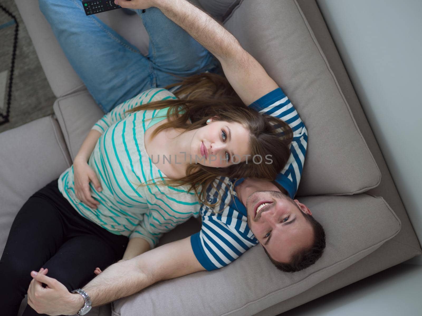 young handsome couple enjoys hugging on the sofa in their luxury home villa