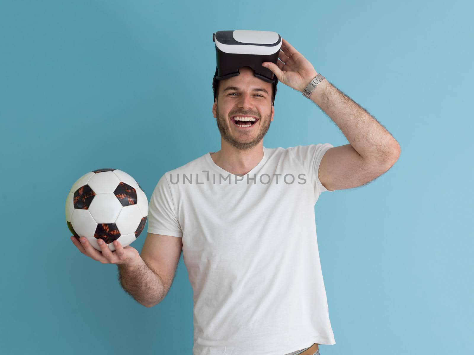 Happy man getting experience using VR headset glasses of virtual reality, isolated on blue background