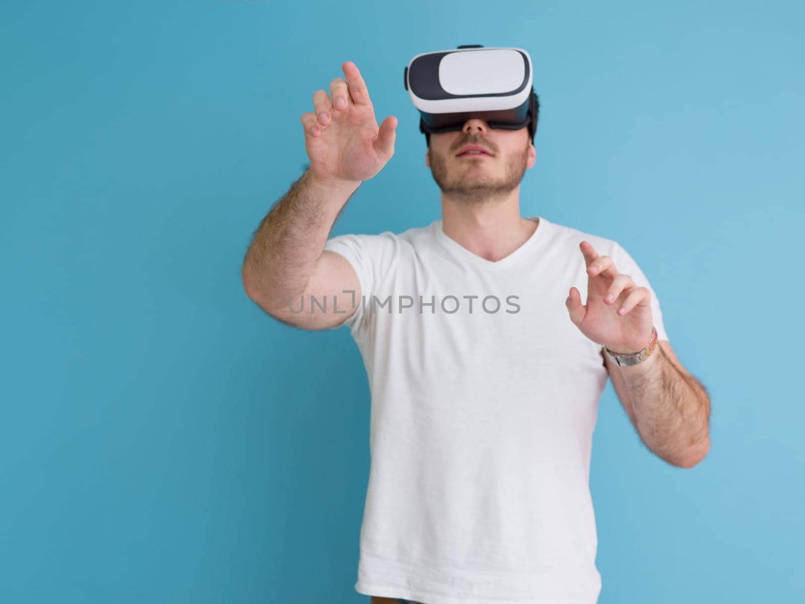 Happy man getting experience using VR headset glasses of virtual reality, isolated on blue background