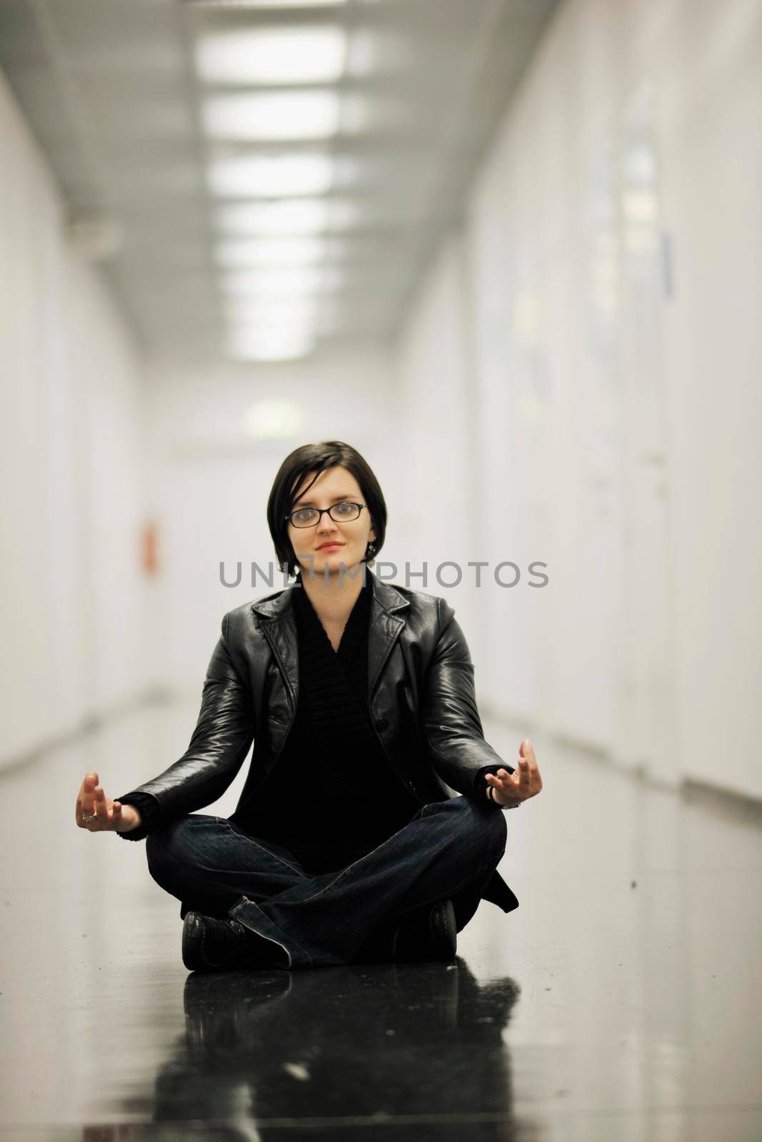 young casual woman sitting and precticing yoga indoor on abstract location