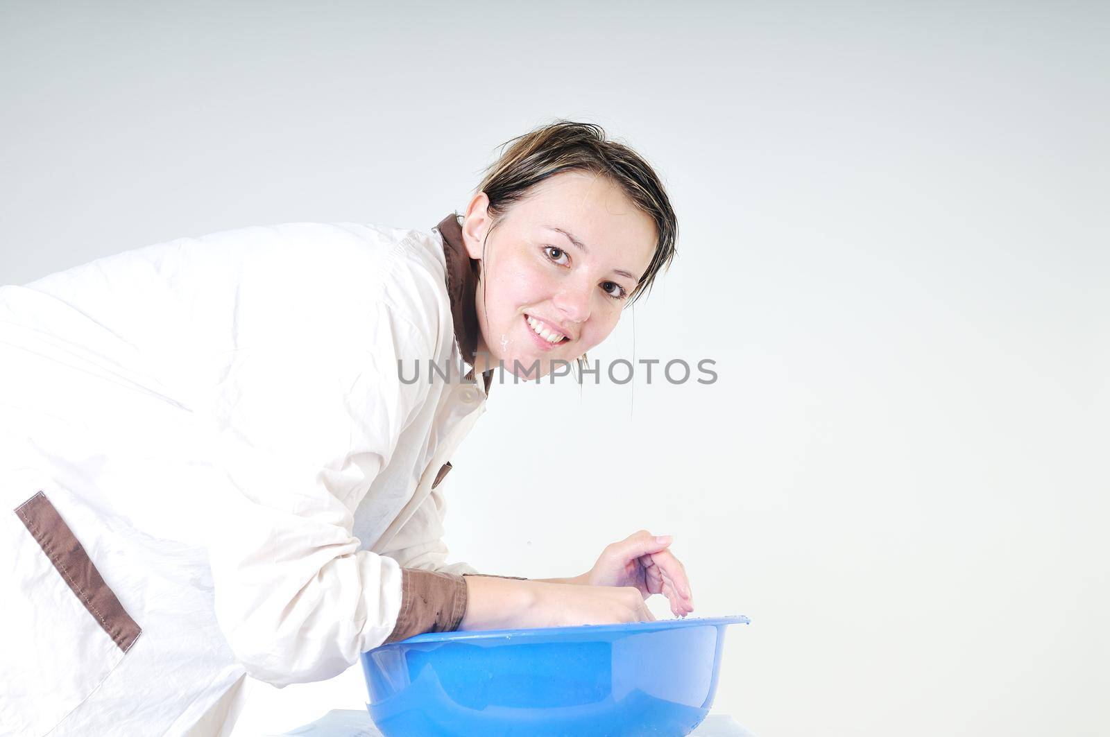 bautiful young woman wash face with clean water isolated on white in studio