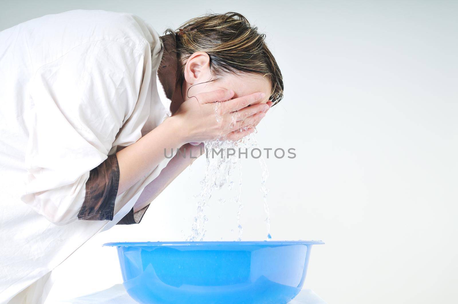 bautiful young woman wash face with clean water isolated on white in studio