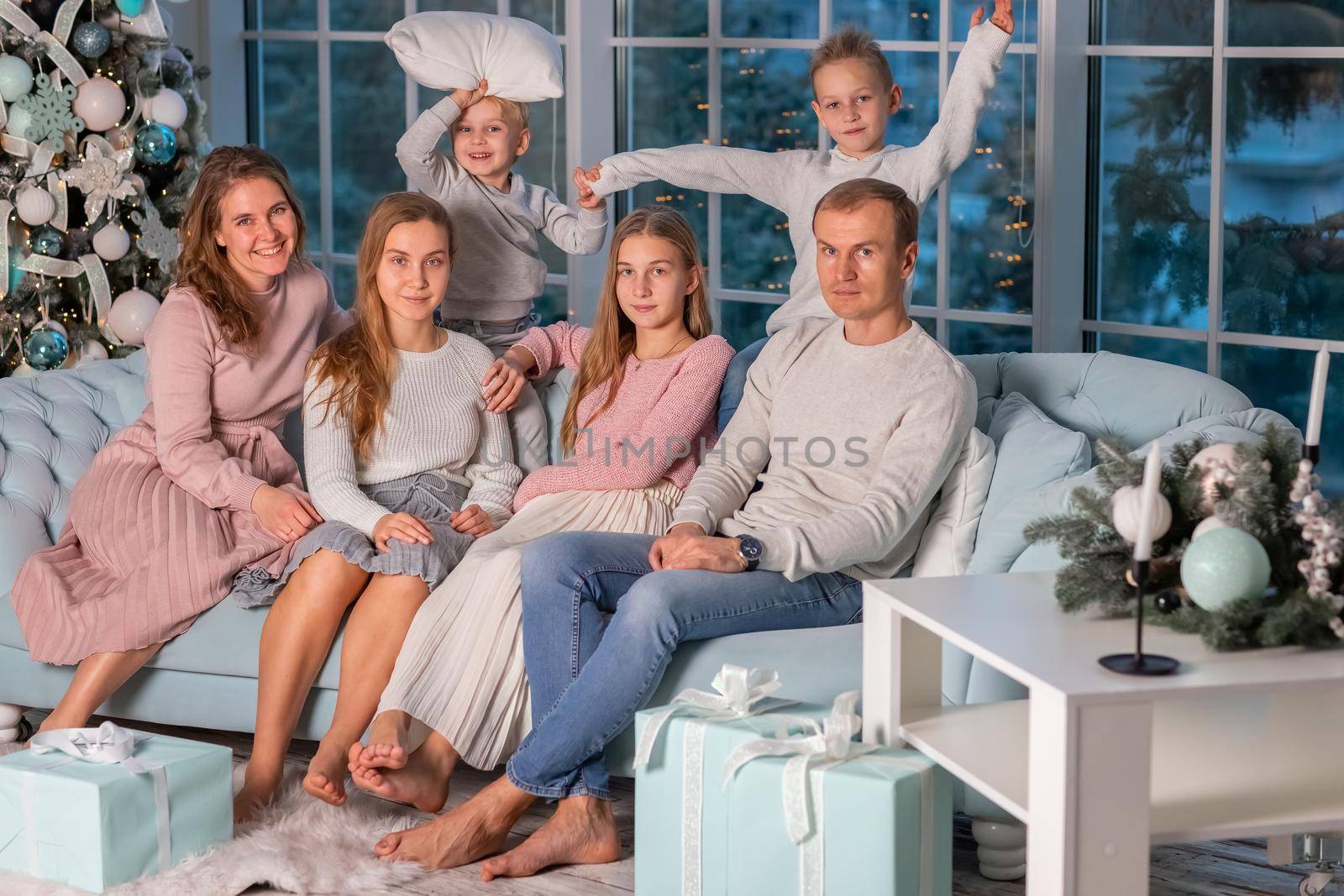 Big Happy family with many kids having fun and pillow fight under the Christmas tree. Christmas family eve, christmas mood concept