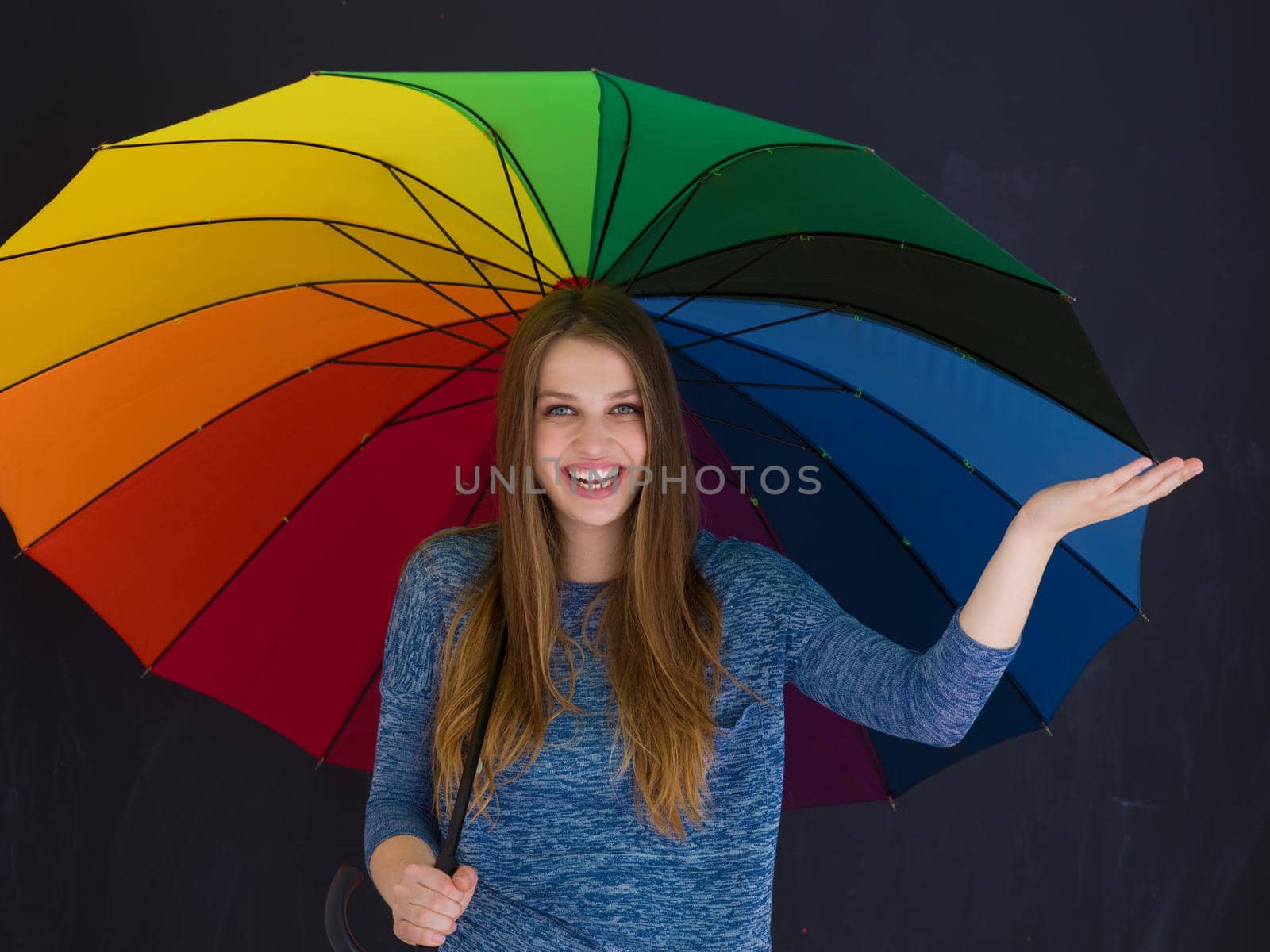 portrait of a young handsome woman with a colorful umbrella isolated on a gray background