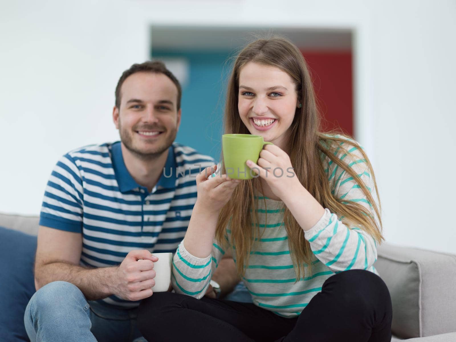 young beautiful handsome couple enjoying morning coffee at home