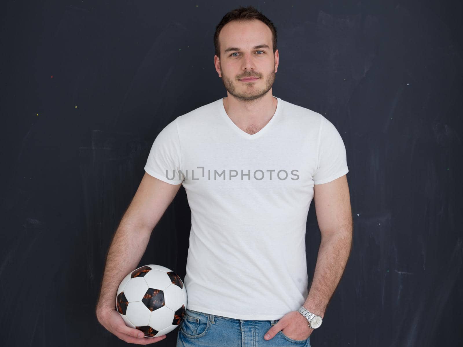 young handsome man playing with soccer ball isolated over grey background
