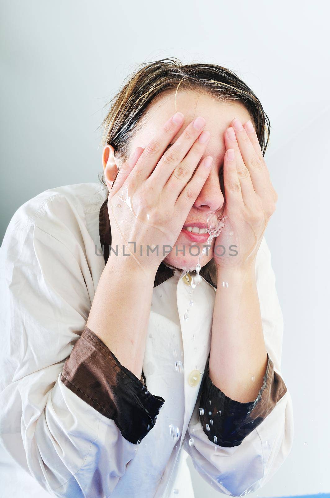 bautiful young woman wash face with clean water isolated on white in studio
