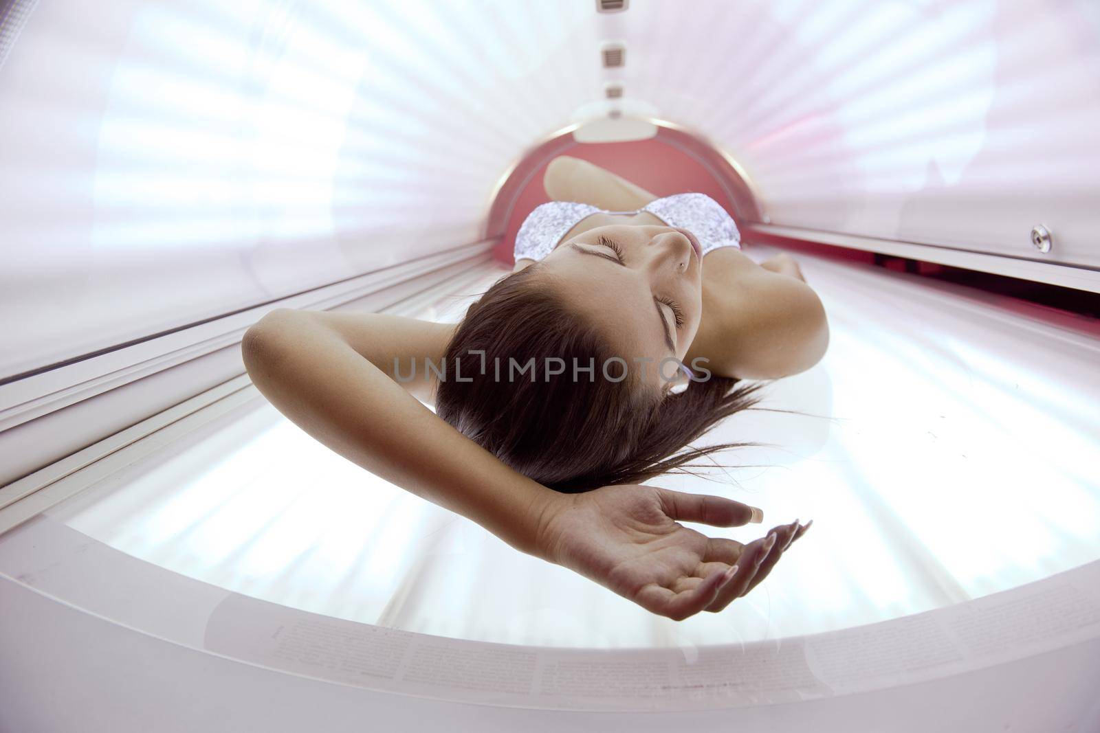 Beautiful young woman have tanning skin treatment in modern solarium